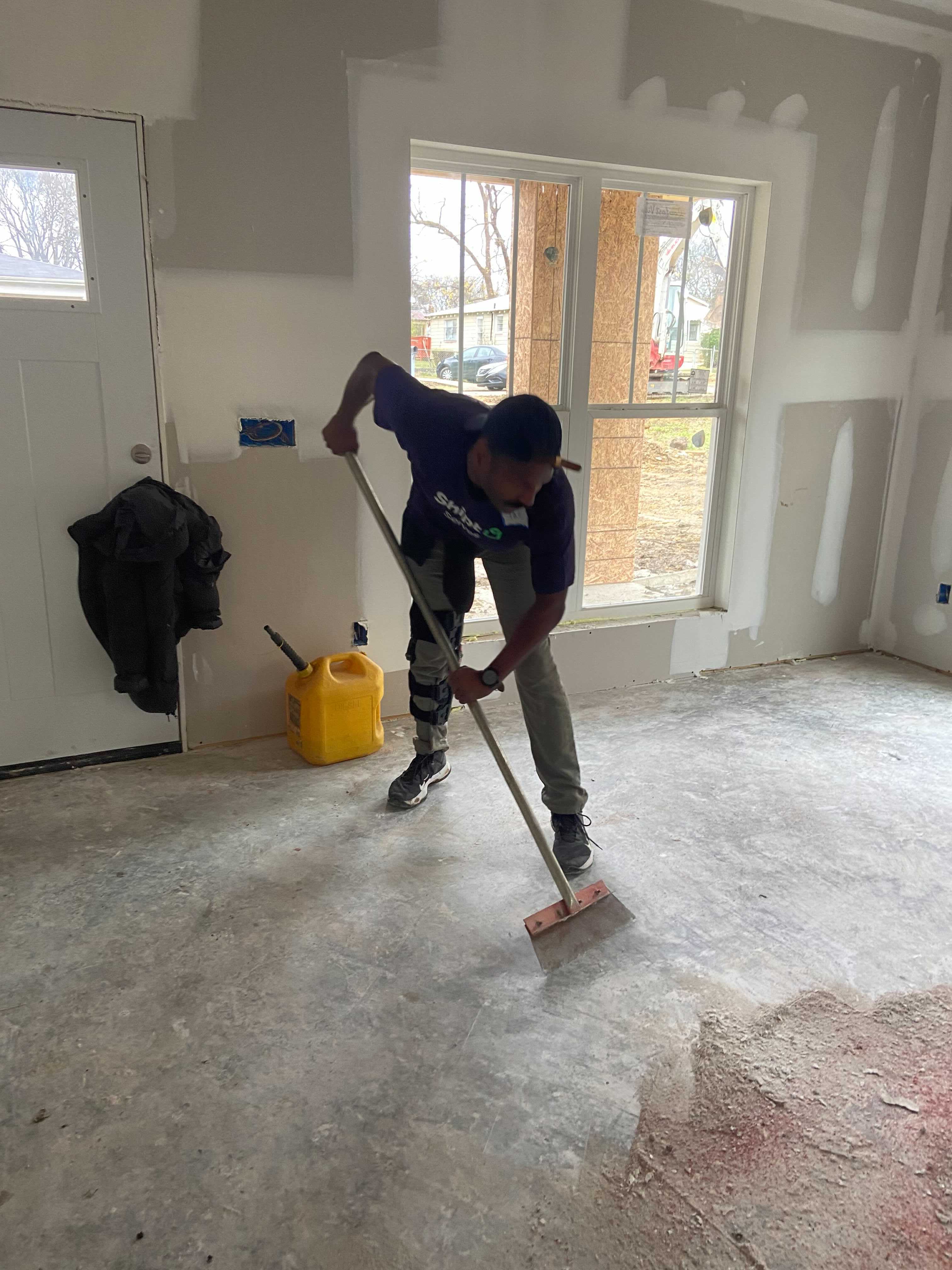 A Shipt Volunteer cleans the floor of one of the Habitat for Humanity homes before another team installed the home’s flooring.